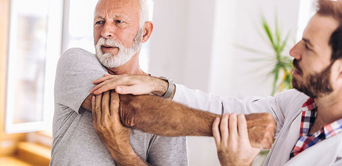 Elderly man receiving shoulder adjustment from Minnetonka chiropractor